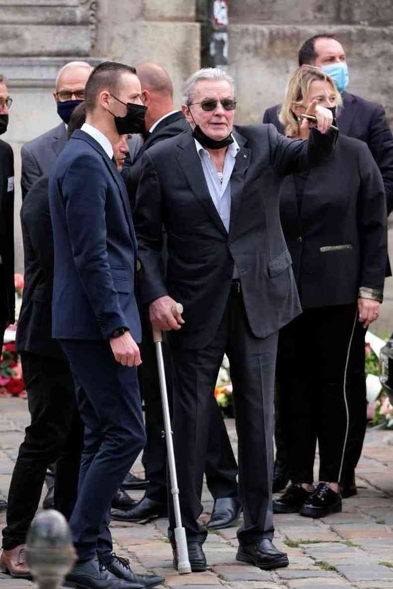 Alain Delon andando com ajuda de uma muleta durante o funeral do também ator Jean-Paul Belmondo em Paris, setembro de 2021