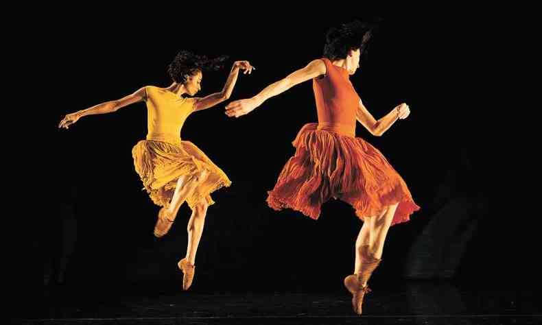 Com roupas em tons fortes de amarelo e vermelho, bailarinas saltam no palco em cena de Primavera