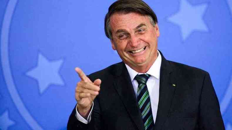Bolsonaro sorri e aponta o dedo