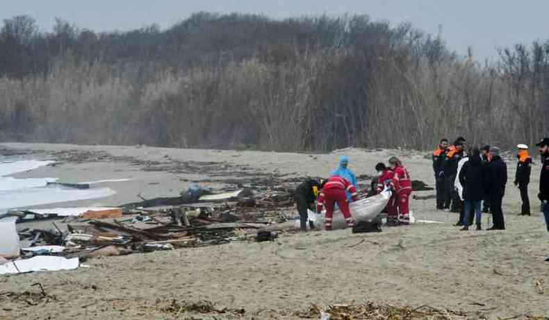 Equipes de resgate carregam um corpo encontrado no local do naufrgio, na Itlia