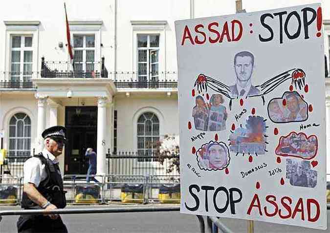 Um cartaz de protesto ao governo de Bashar Al Assad  visto em frente a embaixada sria em Londres (foto: REUTERS/Luke MacGregor )