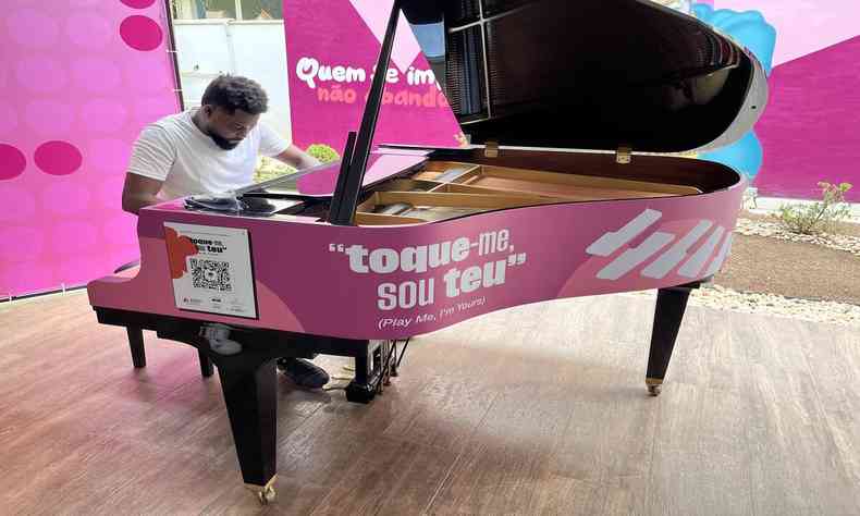 homem de camisa branca tocando piano da cor rosa 