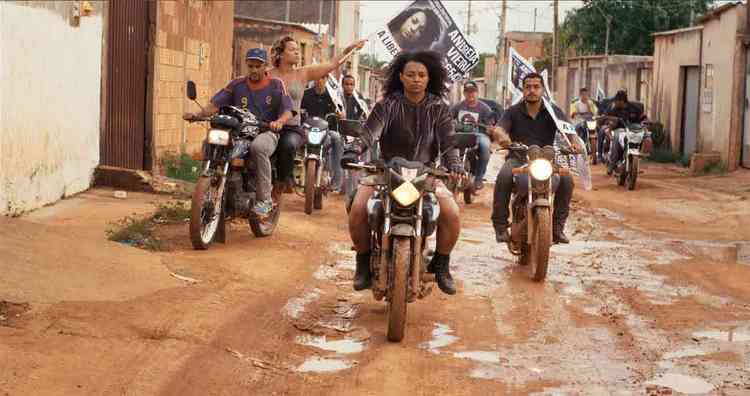 Grupo de mulheres em caravana de motocicletas na periferia de Braslia. Uma delas segura a bandeira de candidata onde est escrito Andreia Vieira



