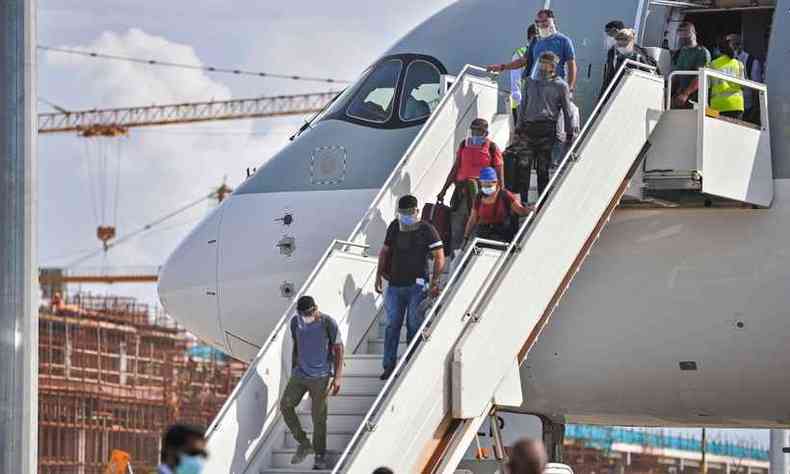 Passageiros desembarcam de voo da Qatar Airways(foto: Ahmed SHURAU / AFP)