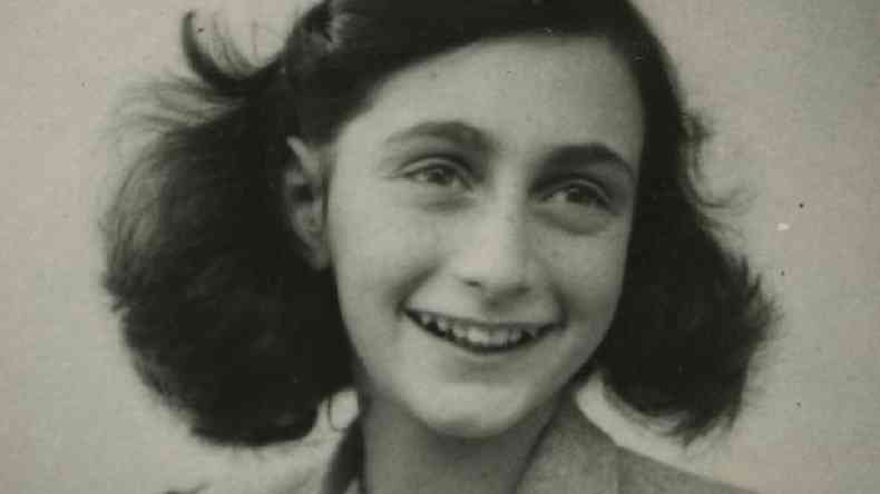 Anne Frank sorrindo em uma foto em preto e branco