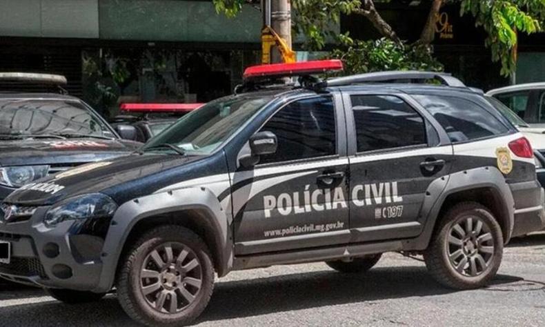 Vitura da Polcia Civil na cor predominatemente preta estacionada em um ptio perto de outros carros. 