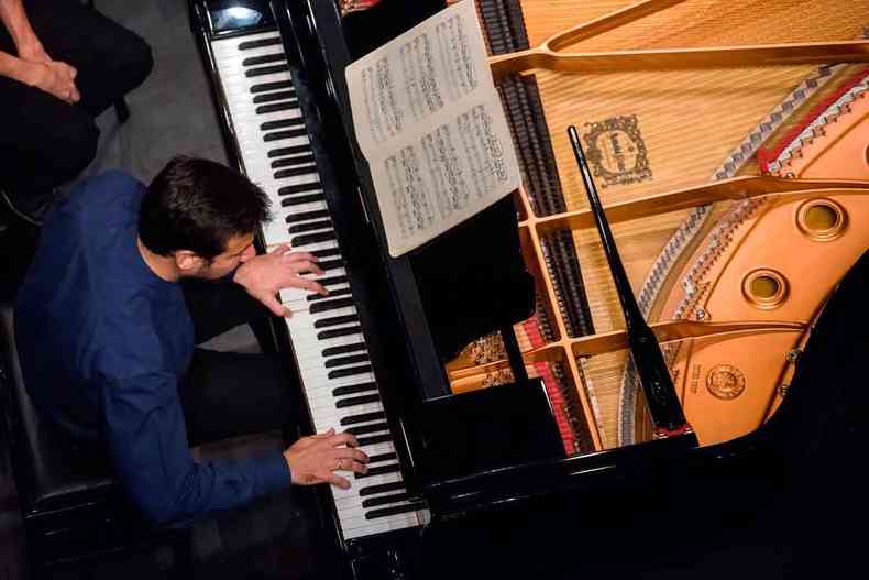 Foto mostra Cristian Budu, tocando piano, visto de cima