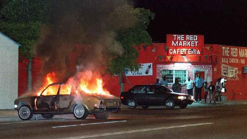 Carro pegando fogo em frente a uma cafeteria