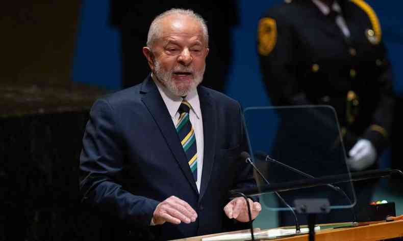Lula, de terno azul escuro, camisa banca e gravata listrada de verde, amarelo e azul, falando em plpito