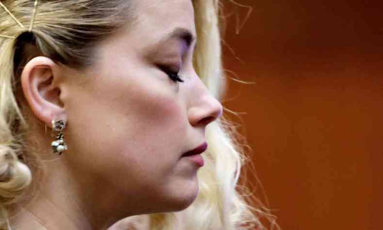 atriz Amber Heard de perfil e olhos fechados,durante julgamento
