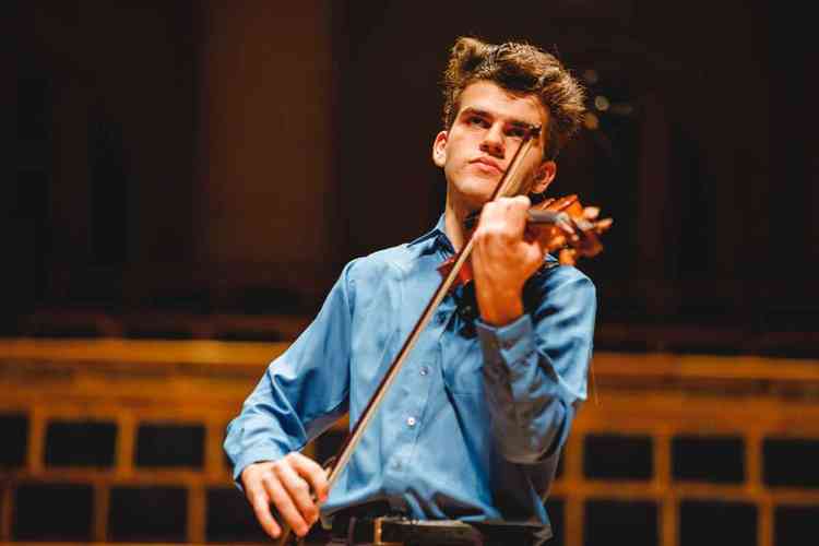 Guido Sant'Anna, vestindo camisa azul, toca violino