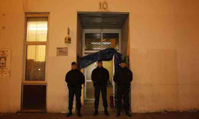 Trs policiais esto de guarda na porta da sede da revista Charlie Hebdo, desde a manh desta quarta-feira(foto: Matthieu Alexandre/AFP)