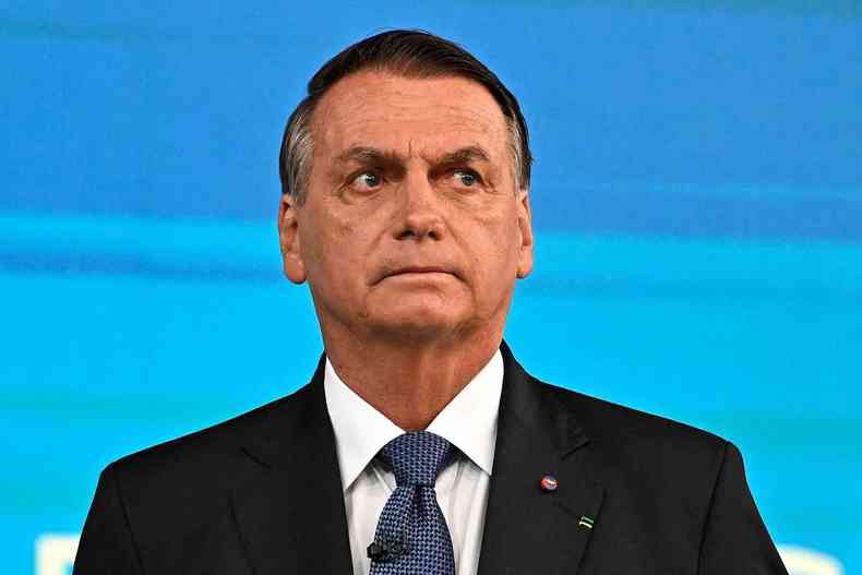 Bolsonaro com expresso de seriedade em foto de fundo azul 