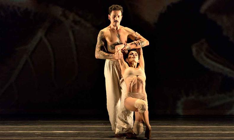 Bailarino e bailarina executam no palco movimento da coreografia Gil