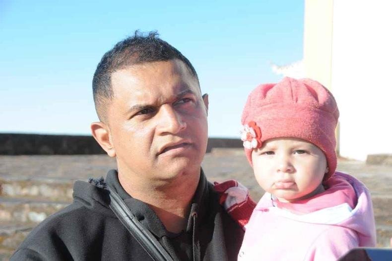 Homem com fila, uma beb�, no colo