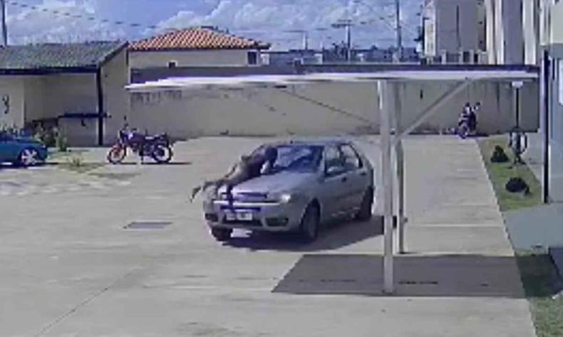 Momento em que a mulher tenta impedir o marido no capô do carro(foto: Reprodução/Redes sociais) Momento em que a mulher tenta impedir o marido no capô do carro