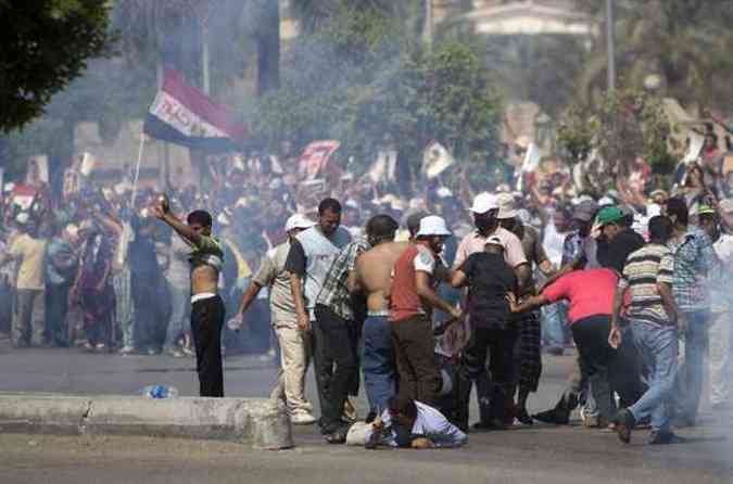 Grupo favorvel a Mursi carrega homem ferido por tiro durante protesto no Cairo(foto: MAHMUD HMS / AFP)