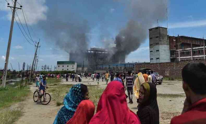 Familiares de trabalhadores estão em busca de notícias de sobreviventes no incêndio da fábrica(foto: Munir Uz zaman / AFP)