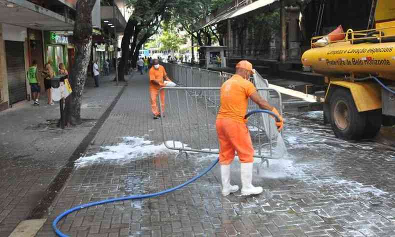 Funcionrios da SLU fazem limpeza do quarteiro fechado da Rua Carijs, na Praa Sete 