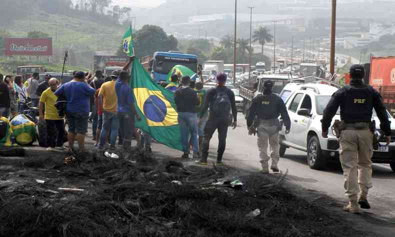 Caminhoneiros na margem da rodovia com bandeira do Brasil 