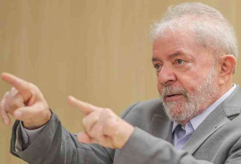 Lula aponta os dedos indicadores das duas mãos enquanto conversa