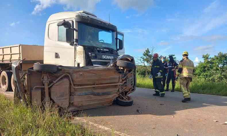 Carro tombado na frente de uma carreta 