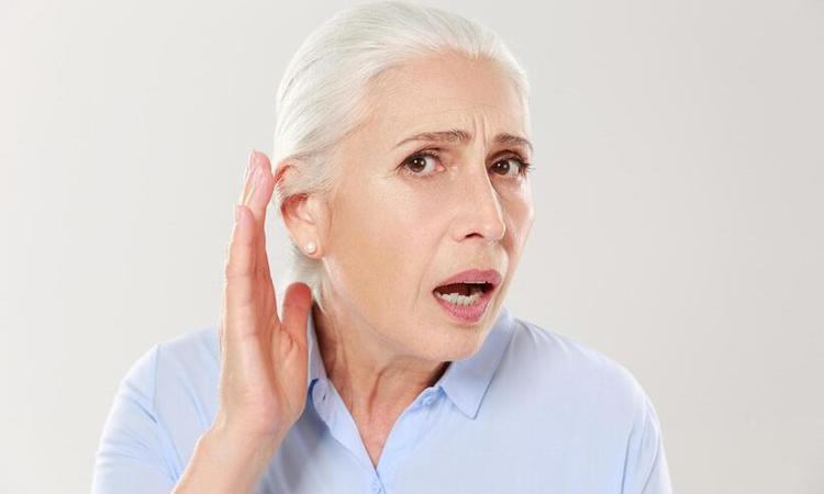 senhora de cabelo branco, mo no ouvido, tentando ouvir 