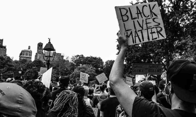 Foto em preto e branco de uma manifestao onde se v vrios cartazes escrito 'Black Lives Mstter'