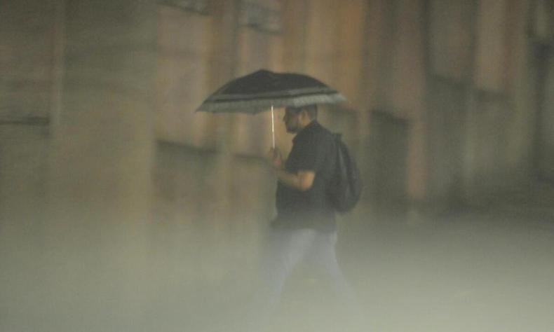 Região Metropolitana de Belo Horizonte terá índices acumulados de chuvas acima da média(foto: Marcos Vieira/EM/D.A press) Homem caminha de guarda-chuva na rua sob temporal