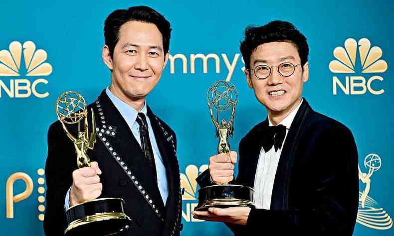 O ator Lee Jung-jae e o diretor Hwang Dong-hyuk sorriem e seguram estatuetas do prmio Emmy