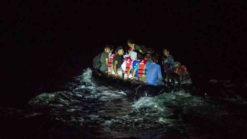 Um bote de borracha cheio de migrantes atravessa a ilha grega de Lesvos  noite - uma das rotas favoritas para os migrantes afegos entrarem na Europa