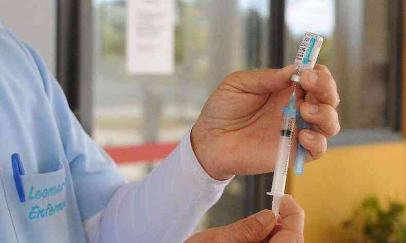 vacina sendo manuseada por trabalhador da sade imunizando pessoas contra a COVID-19