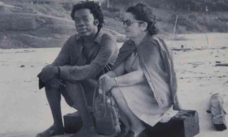 Milton Nascimento e a me, Lilia, sentados num toco, na areia da Praia de Mar Azul