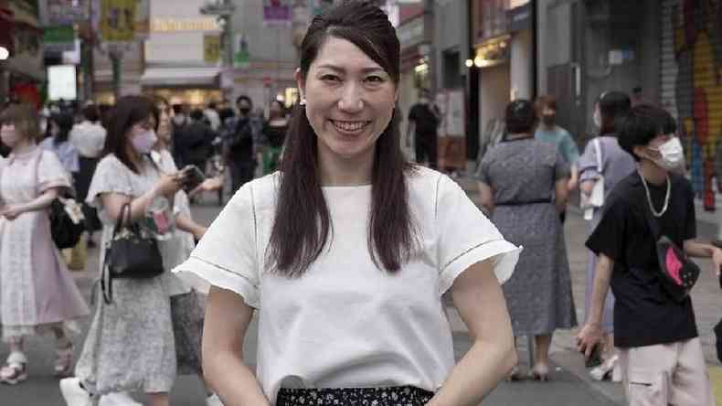 A ativista de sade sexual Asuka Someya parada em frente a uma rua movimentada