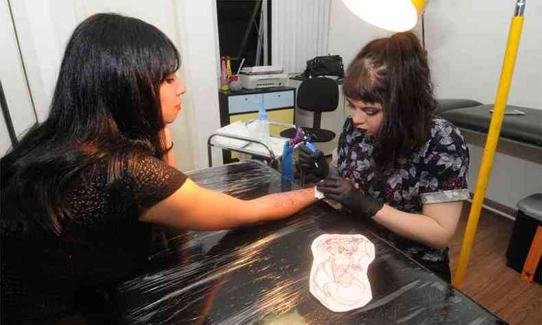 A tatuadora Manoela e Kelly durante sessão que permitiu substituir marcas de cortes por desenho dentro do projeto 'Meu Recomeço'