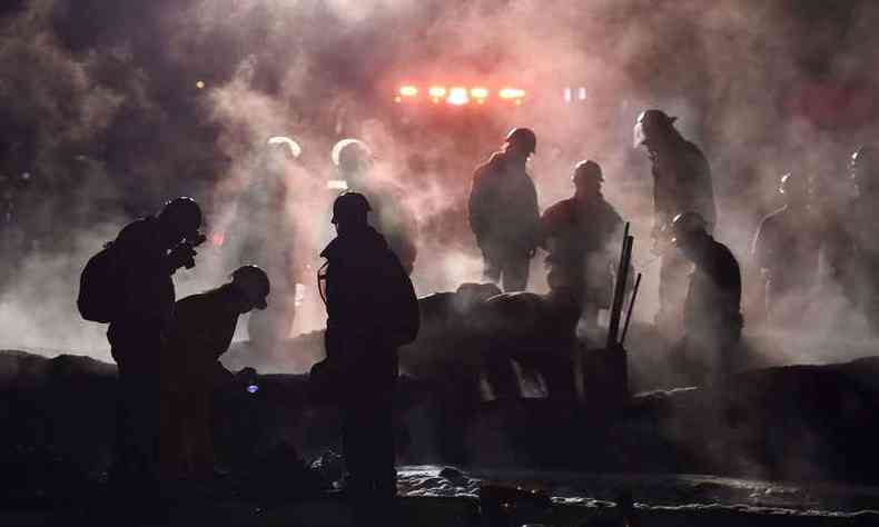 Bombeiros apagam o fogo sobre os corpos das vtimas de incndio em uma tubulao de combustvel (foto: ALFREDO ESTRELLA/AFP)