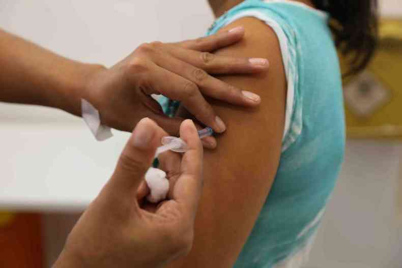 Mulher recebe a dose da vacina contra a gripe no brao