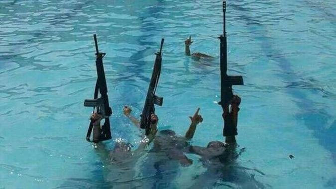 Traficantes ostentam fuzis dentro da piscina da vila olímpica de Honório Gurgel(foto: Jornal Extra/Reprodução) Traficantes ostentam fuzis dentro da piscina da vila olímpica de Honório Gurgel(foto: Jornal Extra/Reprodução)