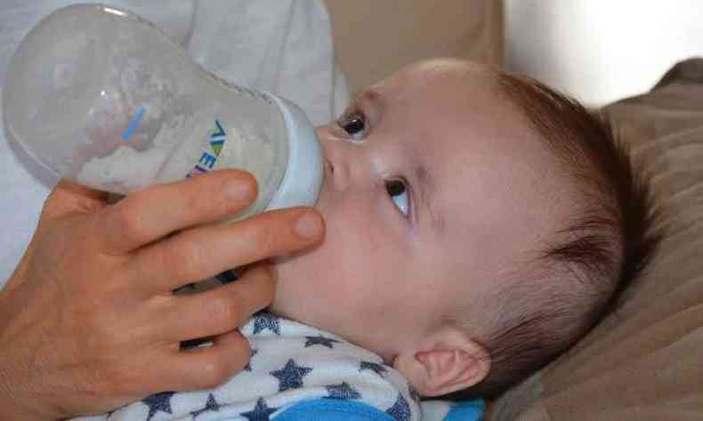 Beb sendo alimentado com leite na mamadeira