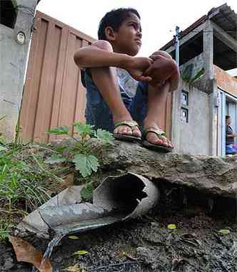 Criana sentada perto de encanamento no Bairro Tup, em Contagem, onde no coleta de esgotos (foto: ( Beto Novaes/EM/D. A Press))