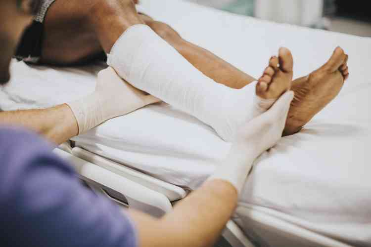 medico ajudando um paciente com fratura na perna