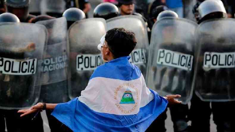 Manifestante coberto com a bandeira da Nicarágua