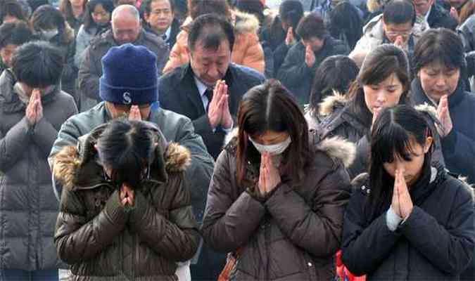 Minuto de silncio pelas vtimas da tragdia na frente de memorial em escola de Okawa (foto: AFP PHOTO / KAZUHIRO NOGI )