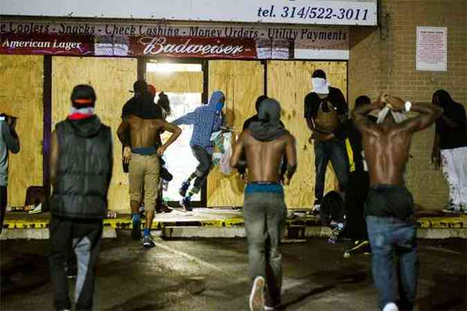 Mascarados levam itens de loja para protestar contra a morte do jovem (foto: REUTERS/Lucas Jackson )