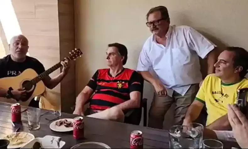 Jair Bolsonaro (PL) chora durante transmisso na qual cantor sertanejo Rick, da dupla com Renner, toca um louvor; ao lado o ex-presidente da Caixa Econmica Federal, Pedro Guimares
