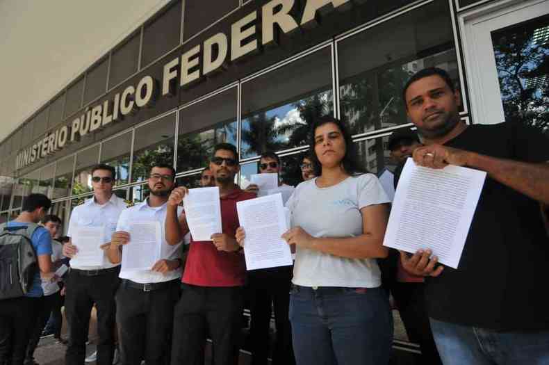 seis pessoas em p e segurando um papel nas mos 