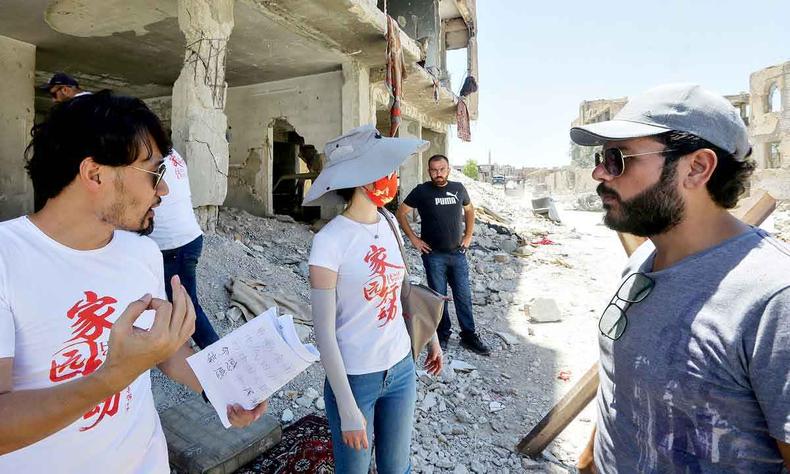 Trs integrantes da equipe de 'home operation' conversam, de p, em meio a escombros que servem de locao para o filme