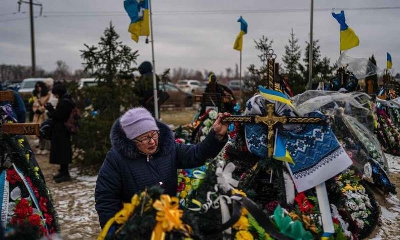 Parentes prestam homenagens às vítimas da guerra(foto: Dimitar DILKOFF / AFP) Cemitério de guerra na Ucrânia