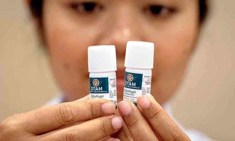 Enfermeira segura dois frascos com leo de canabidiol, medicamento utilizado em pacientes em Bangcoc