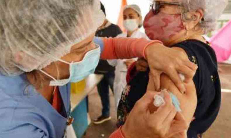 Mulher idosa recebendo vacina contra COVID-19